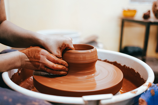 Woman is engaged in pottery. Potter in the process of creating a clay product
