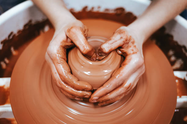 istock Potter forms clay products into future ceramic dishes. Process of creating clay products close-up 1193388257