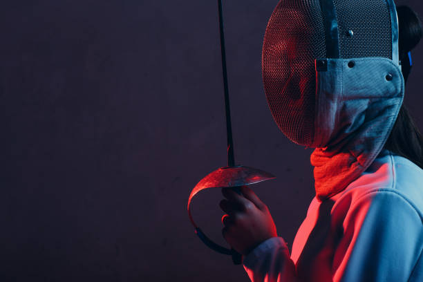 Fencer woman in mask profile portrait with fencing sword. stock photo
