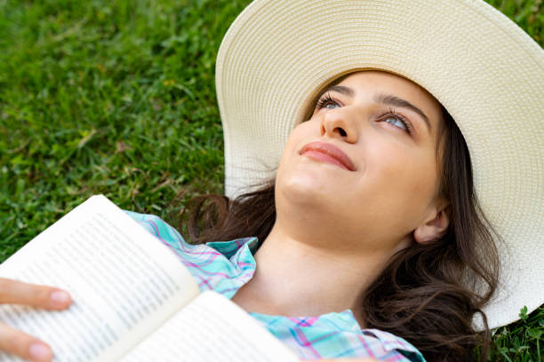 istock Young Girl Lying on Grass and Reading Book. 1193390297