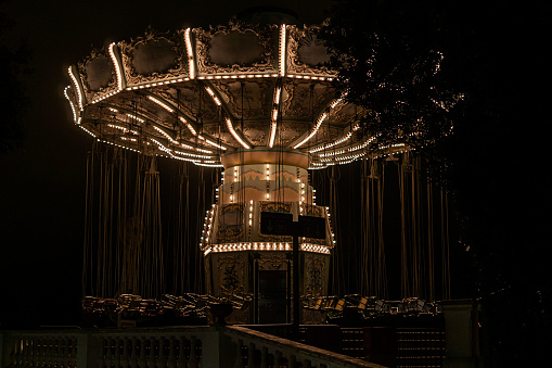 Dark and Moody empty carnival swing. Peaceful or Horror film?