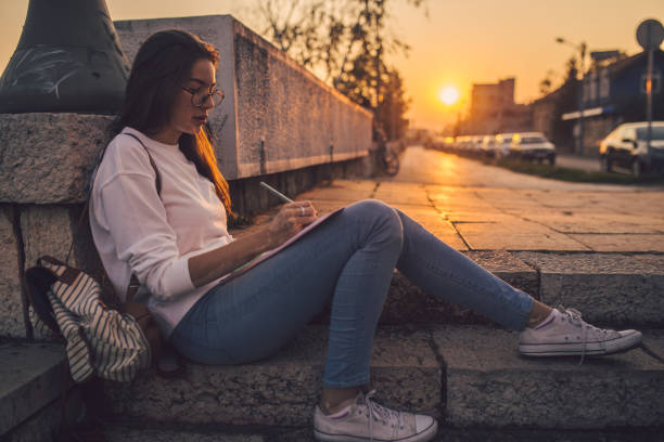 istock Artsy student drawing while sitting on stairs 1193394676