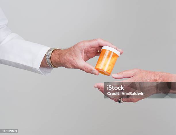 Recipiente Do Comprimido A Ser Transmitidos Pelo Farmacêutico Para O Doente - Fotografias de stock e mais imagens de Comprimido
