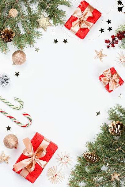istock Christmas frame flat lay with pine, red presents, golden elements, candy canes, confetti. Christmas template on white background. Golden baubles, red gift boxes, pine. Christmas background, copy space 1193395616