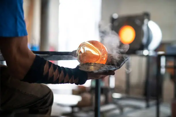 Unrecognizable person working with molten glass.
