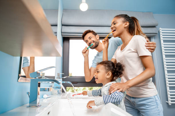 mother, father and daughter brushing teeth in bathroom - hairstyle crest imagens e fotografias de stock