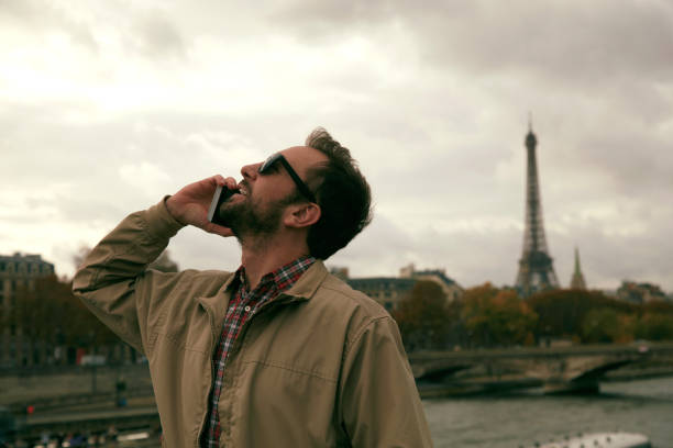 Handsome man talking on cellphone and enjoying in Paris.