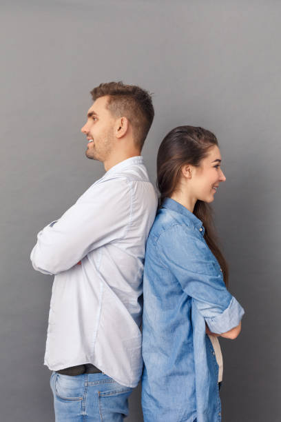 istock Relationship Concept. Young couple studio standing back to back isolated on grey smiling joyful 1193399934