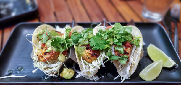 Fresh caught Mahi Mahi fish tacos Fresh caught Mahi Mahi fish tacos with shredded cabbage, avocado, tomatillo salsa, vine-ripened tomatoes, and cilantro on corn tortillas and a side of lime in Maui tomatillo photos stock pictures, royalty-free photos & images