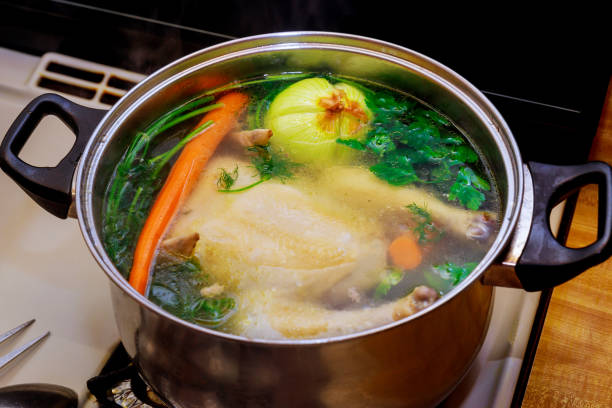 istock Chicken broth with carrots, whole chicken, onion, celery and parsley. 1193409330