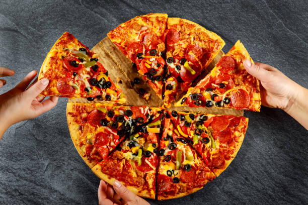 istock Hands taking slices of pizza on dark background. 1193409353