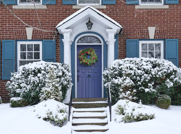 передняя дверь заснеженного дома с рождественским венком - wreath christmas door snow стоковые фото и изображения