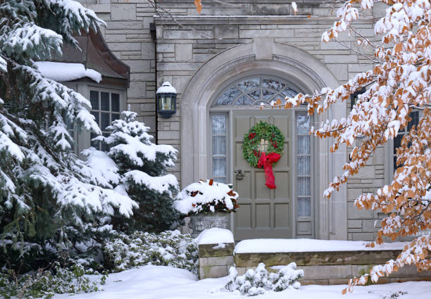 передняя дверь заснеженного дома с рождественским венком - wreath christmas door snow стоковые фото и изображения