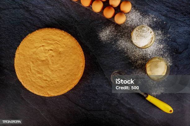 Sponge Cake Biscuit On Dark Background With Ingredients Stock Photo - Download Image Now