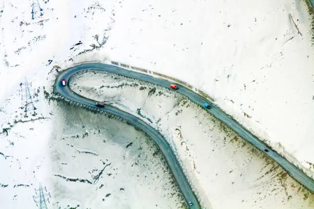 Aerial view of a sharp mountain switchback curve in the Salang Pass roadway through the Hindu Kush in northern Afghanistan. Along the road are avalanche barriers to prevent trucks from being swept over the side of the mountain
