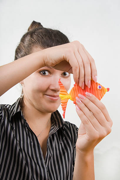 istock The young teacher shows clay fish. 119342162