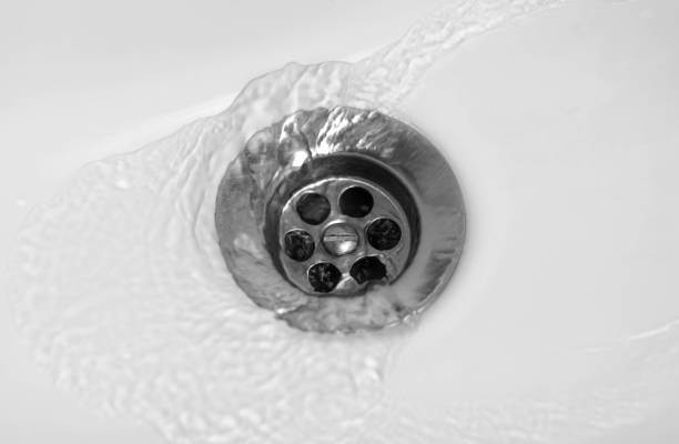 istock Water flows into the middle of a white ceramic sink. Close up 1193425868