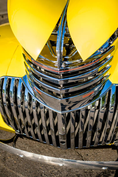 fantazyjny żółty zabytkowy samochód retro z otwartym kapturem z dwóch części i dwoma kratami chłodnicy godowej na wystawie na wojewódzkiej ulicy miejskiej - hood car headlight bumper zdjęcia i obrazy z banku zdjęć
