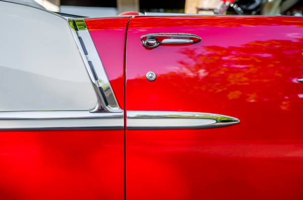 side of an open bright red vintage retro convertible car with chrome details and moldings exhibited at a provincial town street exhibition - collectors car antiquities ancient past imagens e fotografias de stock