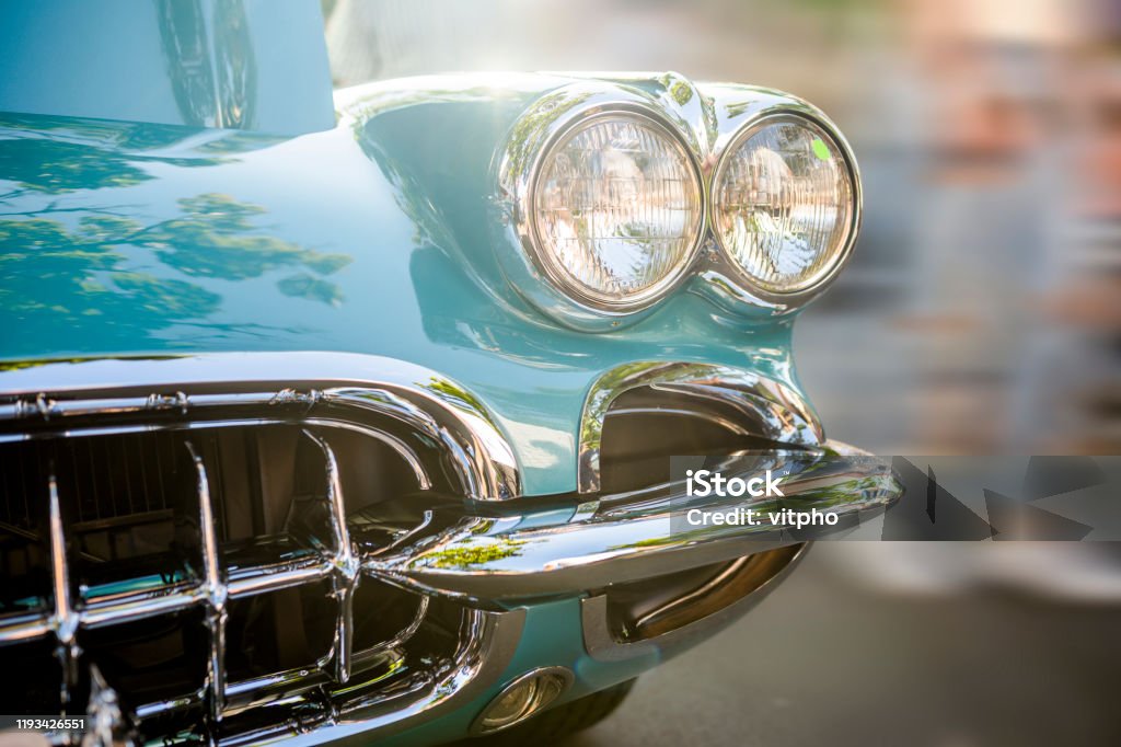 Old turquoise vintage retro car with double round headlights standing at an exhibition on a street of a provincial town in the sunlight Fancy turquoise vintage retro car attracting the attention of visitors and amateurs of antiquity not only in the car"u2019s excellent condition and shape but also unique applied engineering solutions Vintage Car Stock Photo