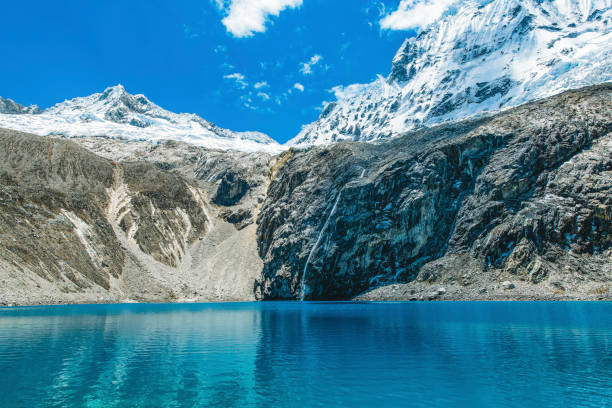 アンデス山脈に高い滝を持つクリスタルクリア氷河湖 - huaraz ストックフォトと画像