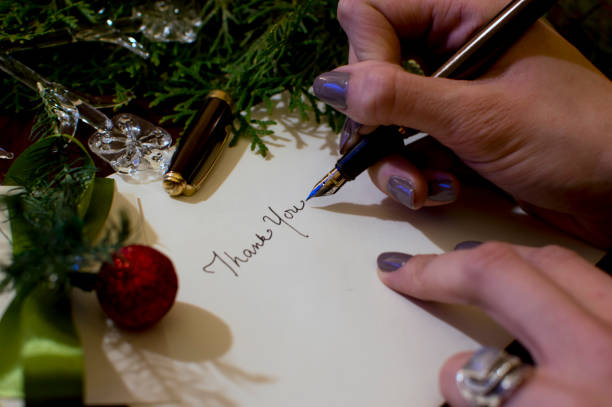 frau schreiben weihnachtskarte schreiben danke mit evergreen und ornamente hintergrund - christmas christmas card greeting card greeting stock-fotos und bilder