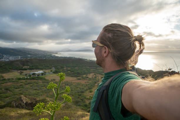 istock Young man in Honolulu taking selfie from top of volcano 1193449321