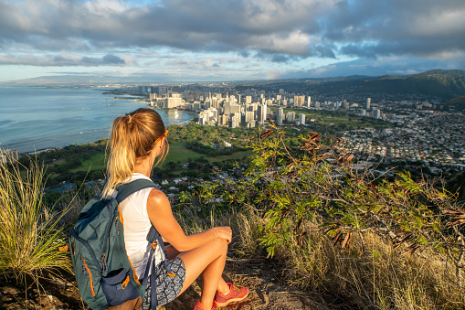 Young woman on mountain top overlooking the city of Honolulu, Oahu, Hawaii, USA