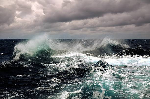 Dark clouds and crashing ocean waves stock photo