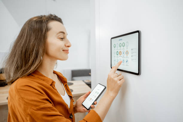 istock Woman controlling smart devices with a digital tablet at home 1193452704
