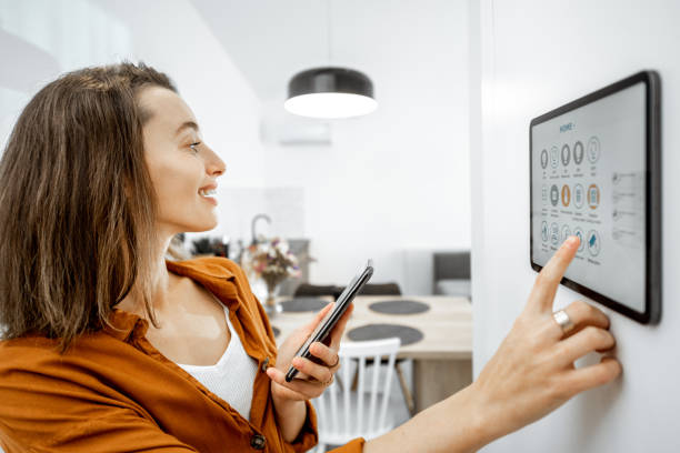 istock Woman controlling smart devices with a digital tablet at home 1193452705