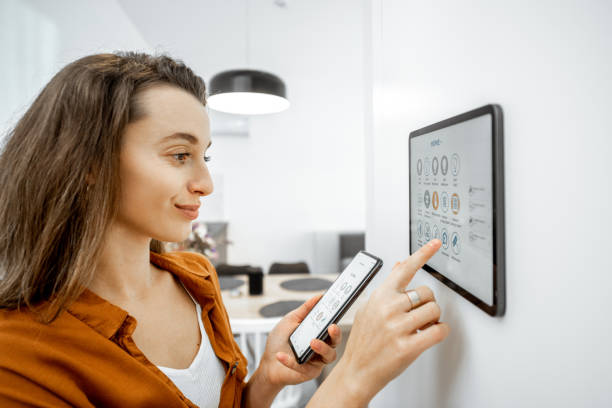 istock Woman controlling smart devices with a digital tablet at home 1193452712