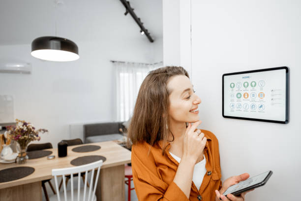 istock Woman controlling smart devices with a digital tablet at home 1193452718