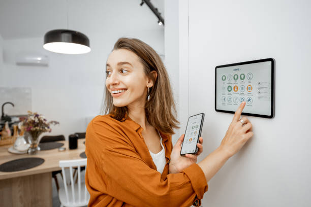 istock Woman controlling smart devices with a digital tablet at home 1193452736