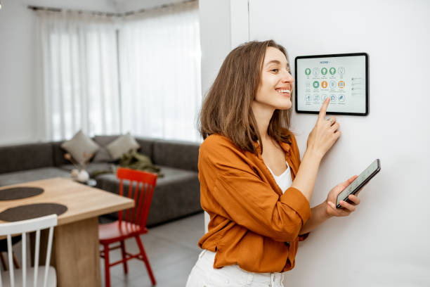 istock Woman controlling smart devices with a digital tablet at home 1193452749