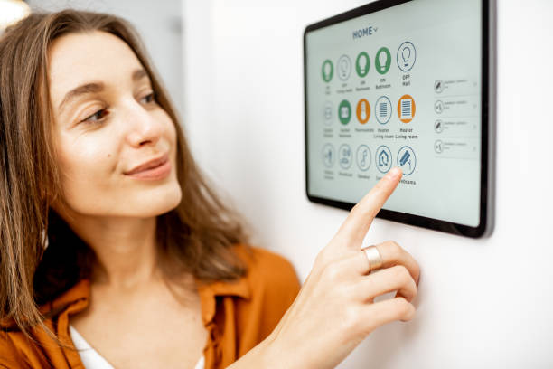 istock Woman controlling smart devices with a digital tablet at home 1193452750