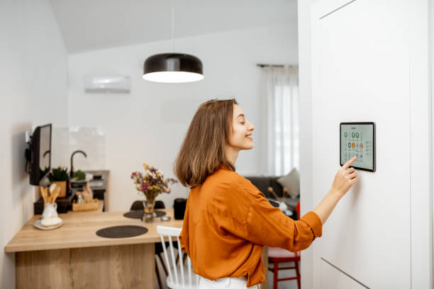 istock Woman controlling smart devices with a digital tablet at home 1193452773