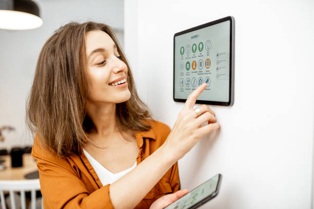 istock Woman controlling smart devices with a digital tablet at home 1193452790