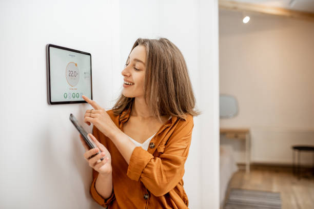 istock Woman controlling heating with a smart devices 1193452804