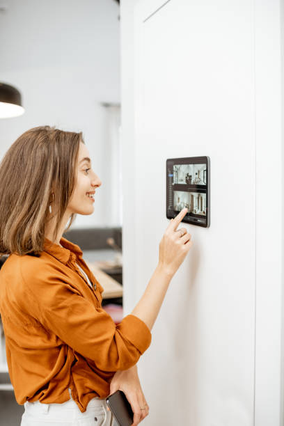 istock Woman controlling home with video cameras and digital tablet 1193452822