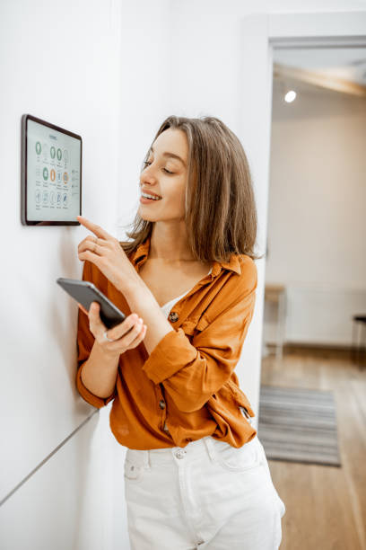 istock Woman controlling smart devices with a digital tablet at home 1193452844