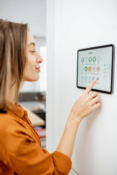 istock Woman controlling smart devices with a digital tablet at home 1193452845