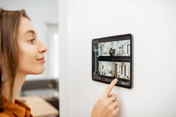istock Woman controlling home with video cameras and digital tablet 1193452853