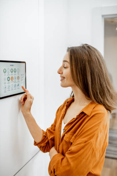 istock Woman controlling smart devices with a digital tablet at home 1193452925