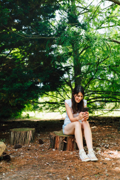 istock Young woman text messaging outdoors 1193453604
