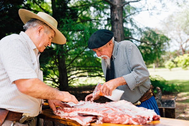 istock Two senior Argentinian gauchos preparing traditional barbecue 1193453915