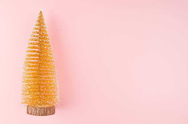 istock Elegant golden christmas tree on soft light pastel pink background, top view, copy space, border. 1193454704