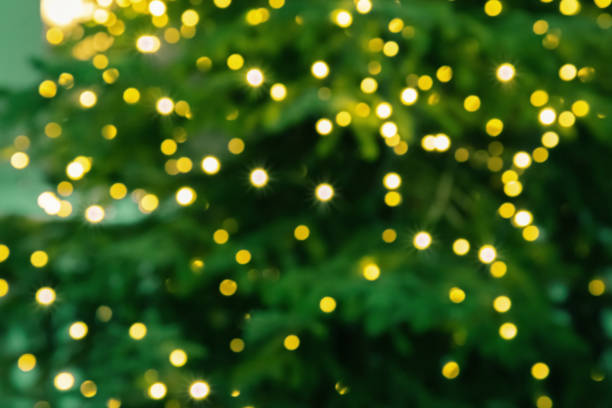 istock Abstract blur lights on green background. Blurred yellow round glitters. Christmas tree lights. 1193454820