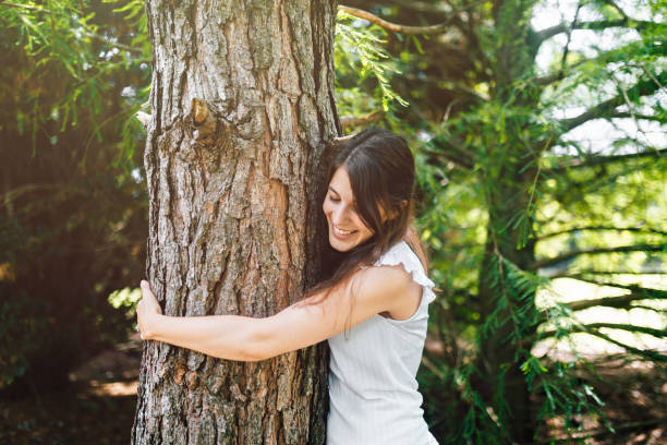 istock Happy young woman hugging a tree 1193455064