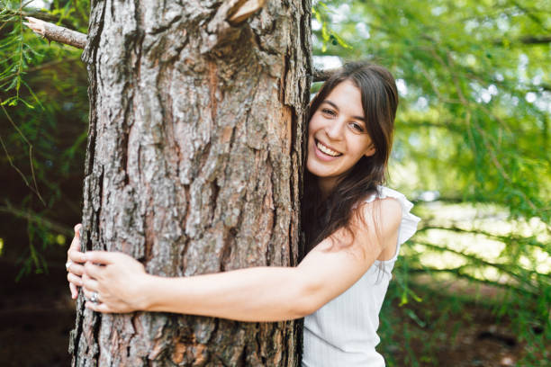 istock Happy young woman hugging a tree 1193455087